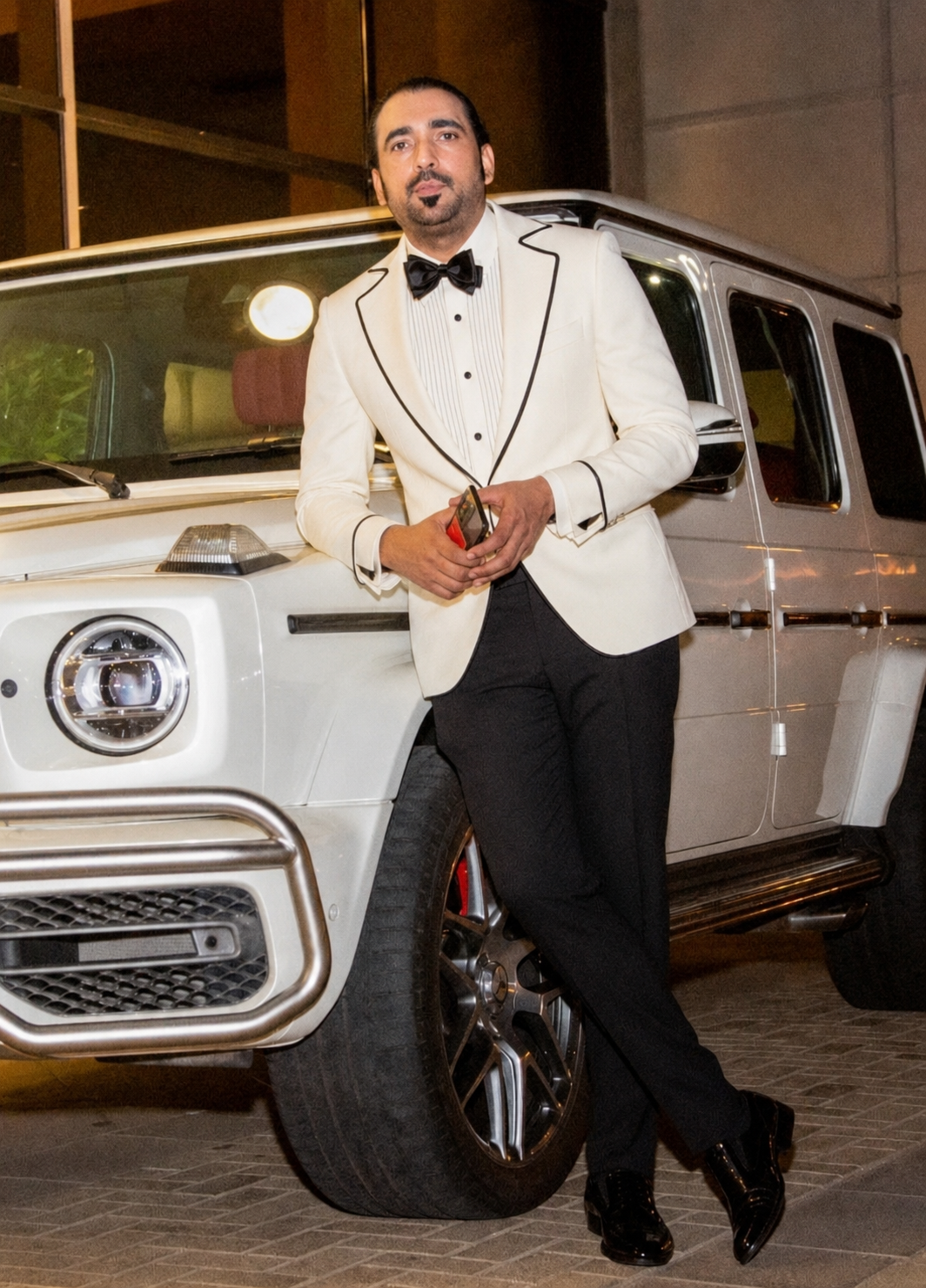 Syed Mudassar Khushnood in white tuxedo with Mercedes G-Wagon